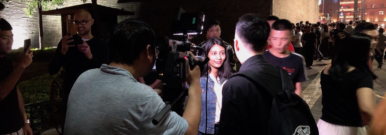 Slide Image: PhD student Kesina Baral being interviewed by a local TV station at the IEEE International Conference on Software Testing, Verification, and Reliability in Xi'an China.
