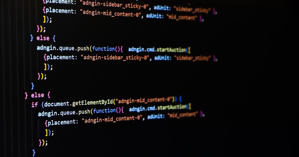Close-up of a computer screen showing lines of colorful programming code in JavaScript, with functions, conditions, and syntax highlighted against a black background.